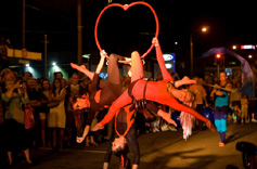 Three aerialists hang from an aerial hoop in the Cuba St Carnival Parade 2007 